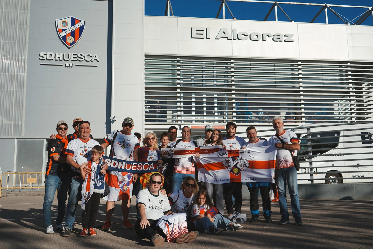 Miembros de la Peña SD Huesca Cinca Medio junto a El Alcoraz.