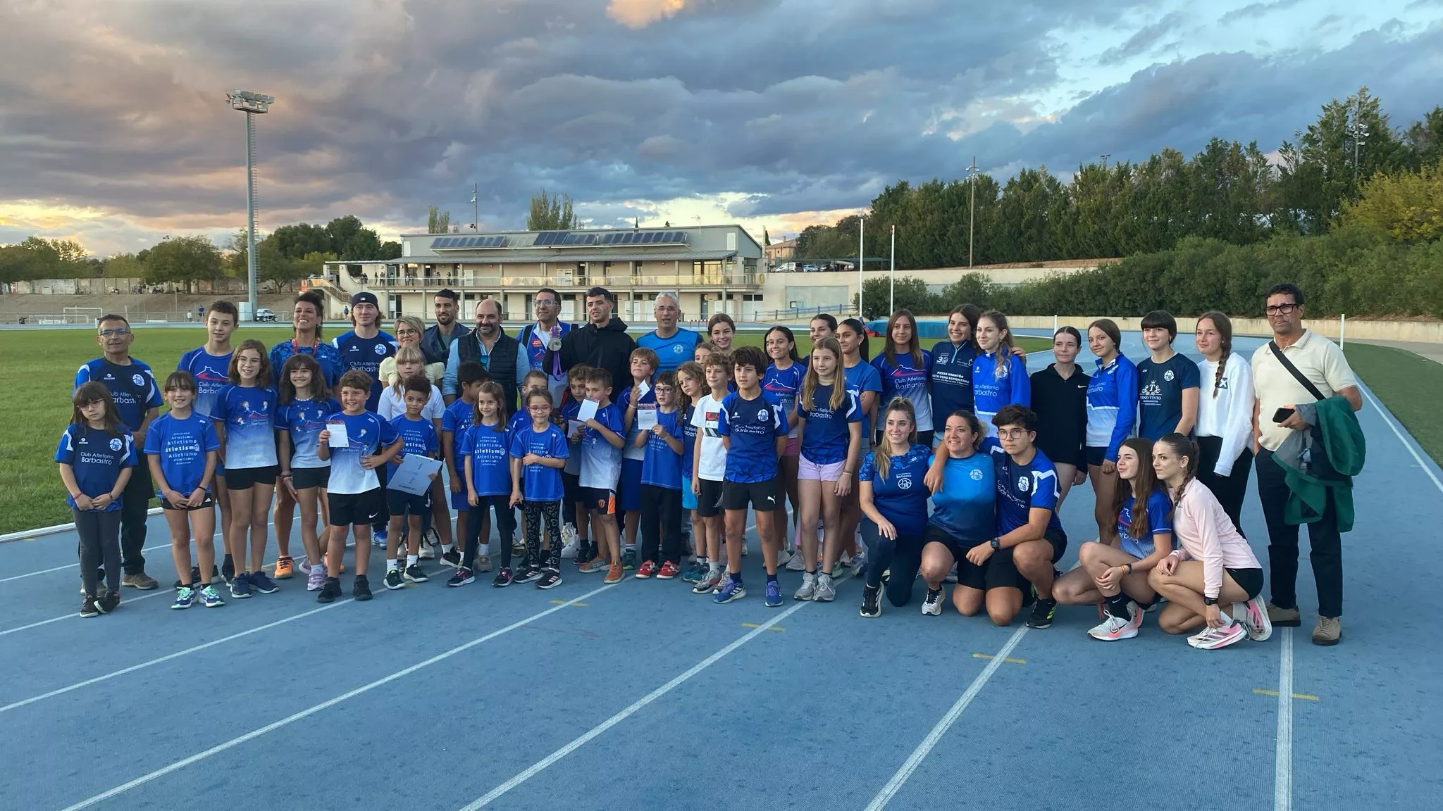 Sedjati con atletas del CAB en las pistas de Barbastro, y el alcalde Fernando Torres.