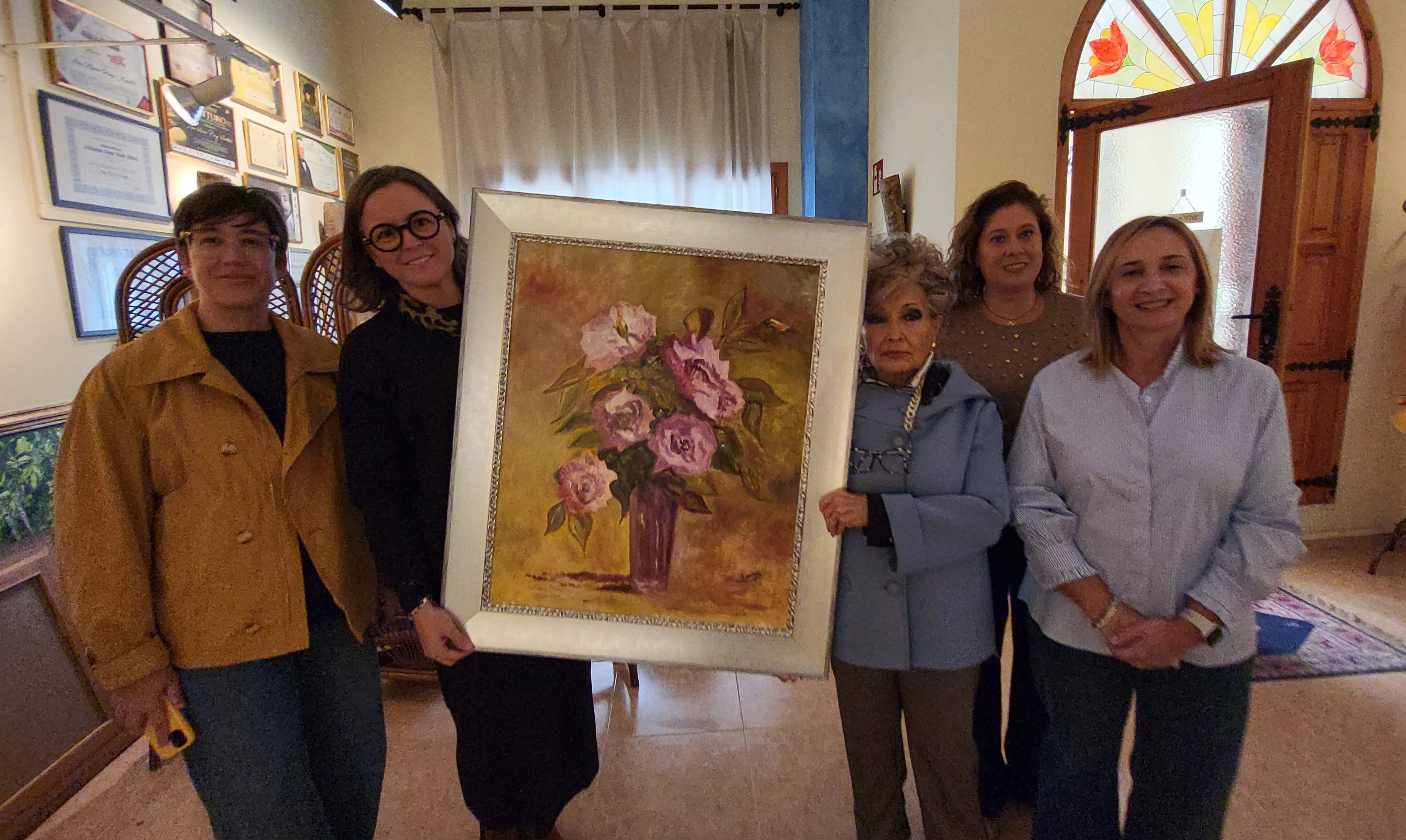 Ana María Pueyo y la alcaldesa de Zaidín sujetan el cuadro cedido por la artista, acompañadas de integrantes de la Asociación de Mujeres. Foto Mercedes Manterola