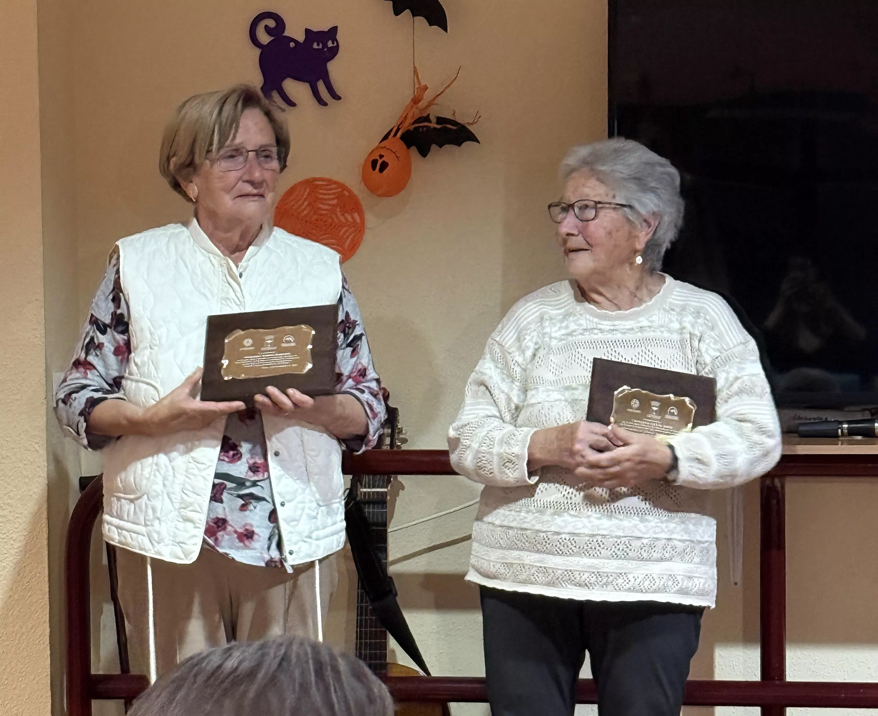 Merche Torres y Trini Grasa sostienen el reconocimiento recién entregado.