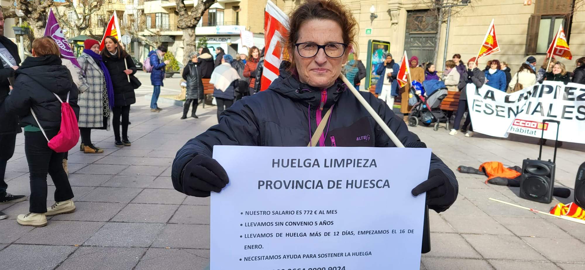 Una de las huelguistas con el cartel informativo y el número de la caja de resistencia