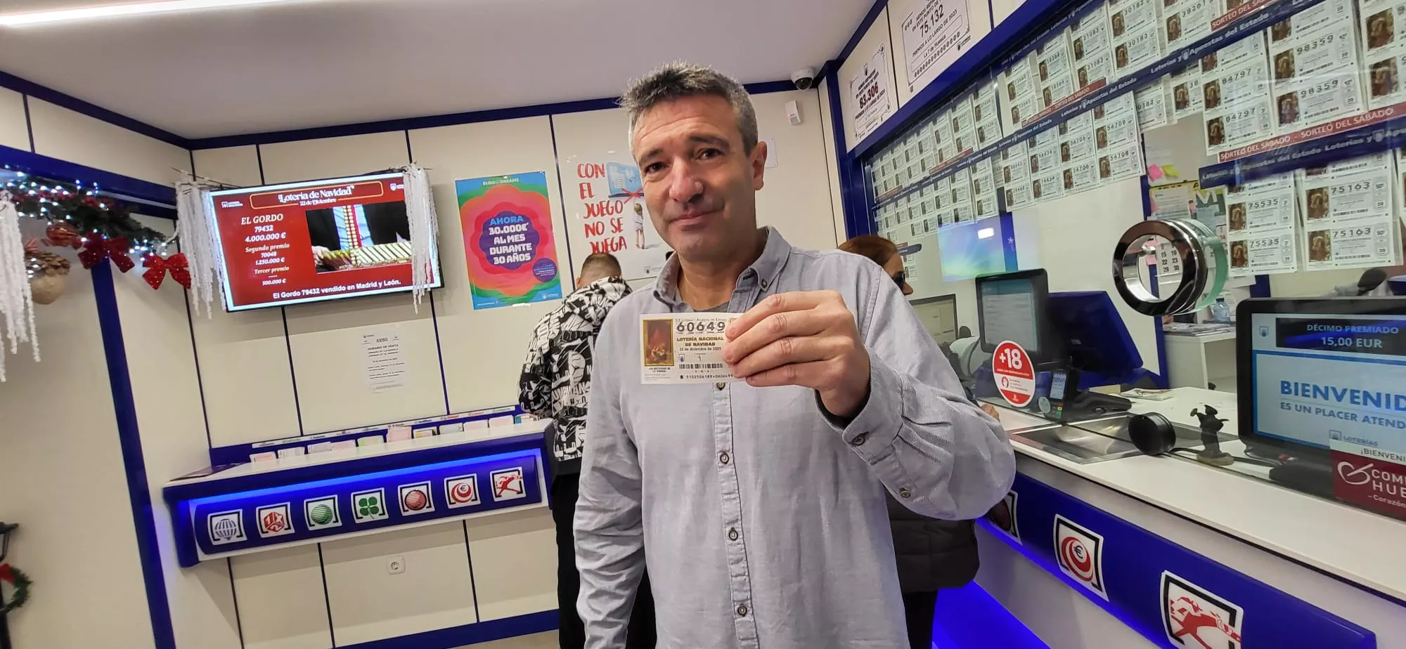 Fernando Alagón muestra un décimo del quinto premio que ha vendido en la administración La 7 de Huesca.