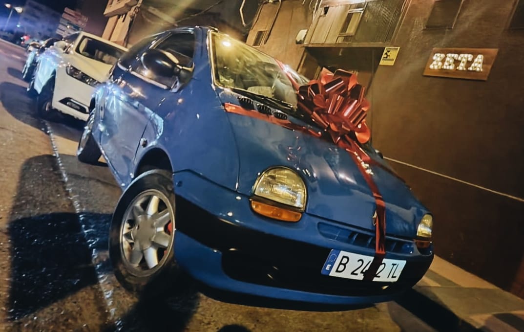 El Twingo sorteado ante la puerta de uno de los establecimientos.