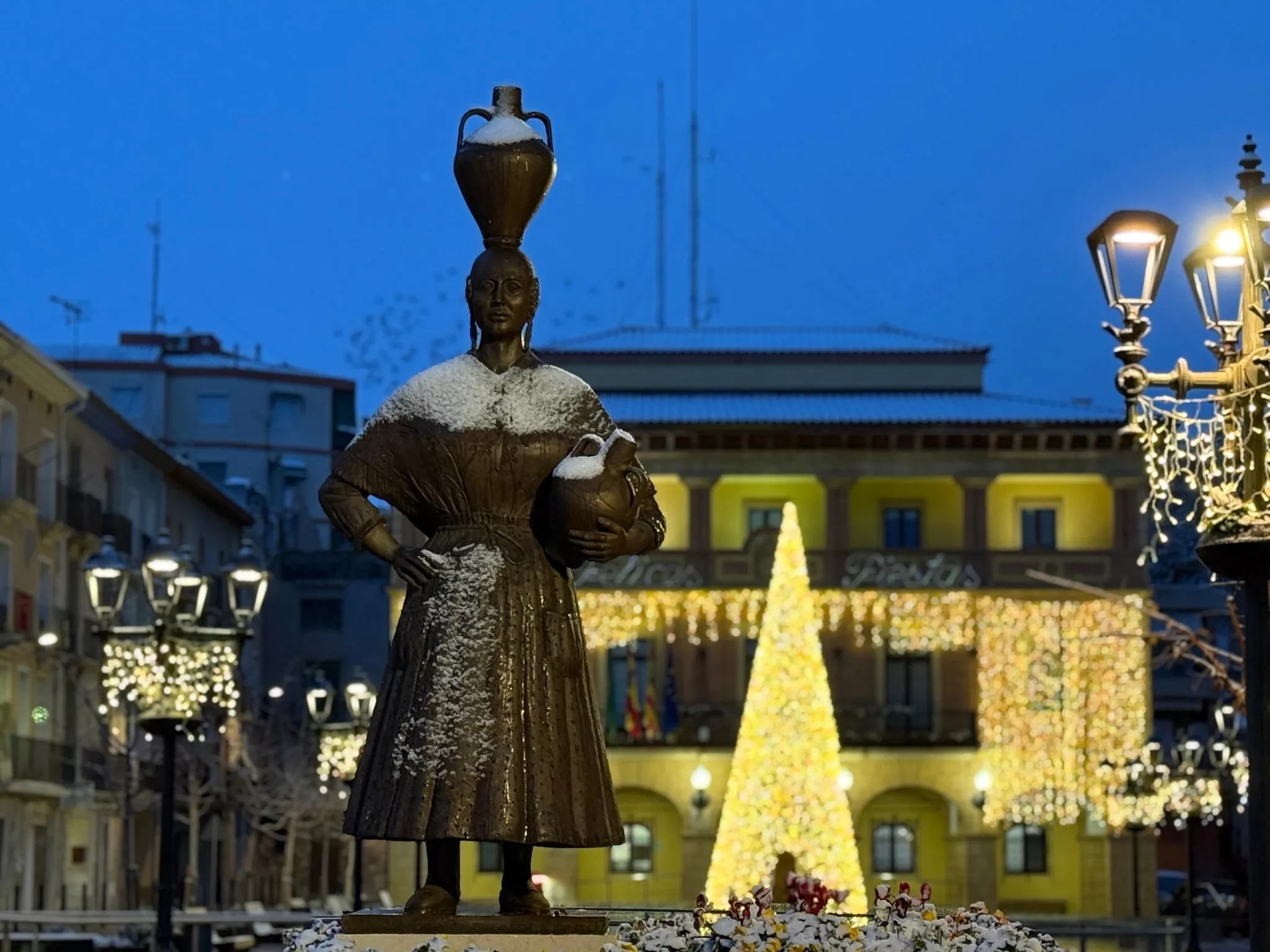 La nieve ha llegado a Fraga dejando esta estampa de la escultura de la Fragatina.