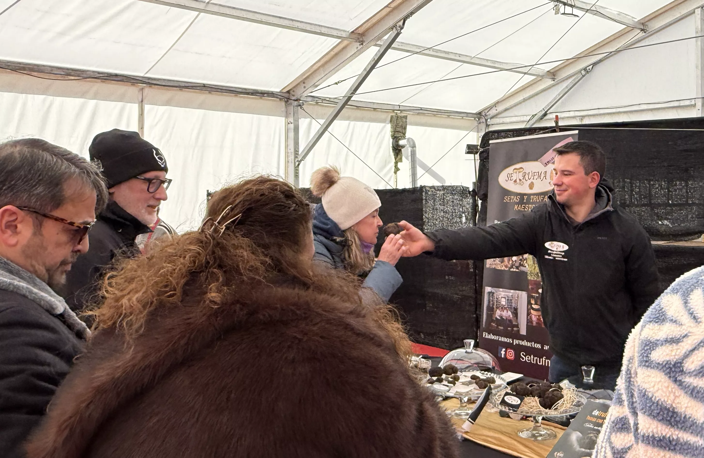 Público oliendo trufa en uno de los puestos