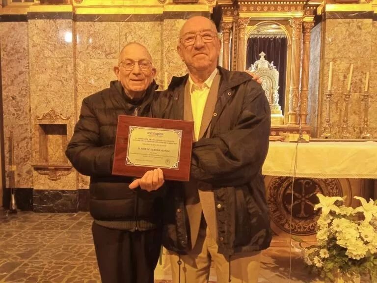 Paco Lacau entrega una placa a Chema Ferrer en un homenaje en Escolapios