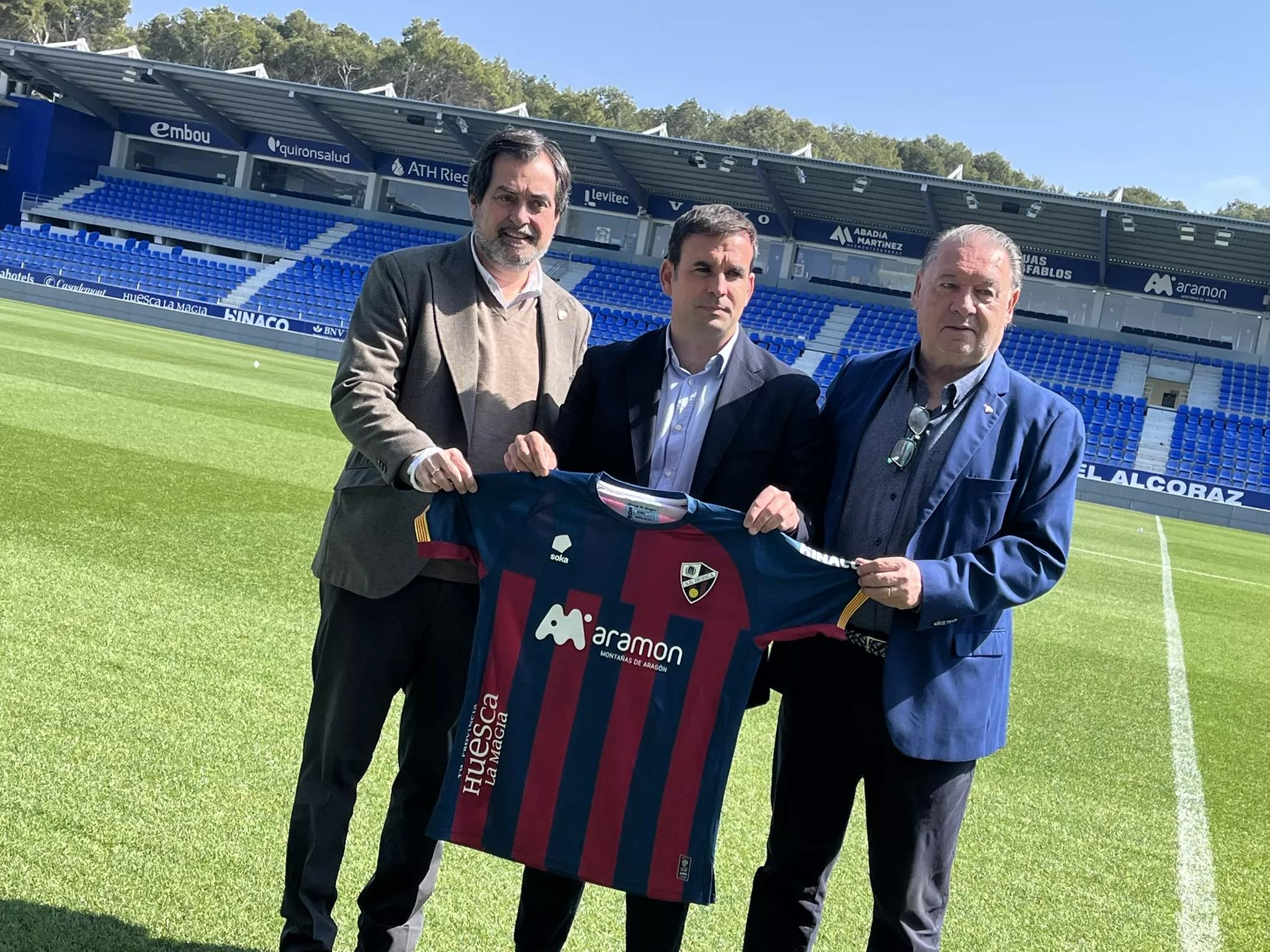 Mur, Sanz y Lasaosa, sobre el césped de El Alcoraz en la presentación del nuevo director deportivo. Foto: Adri Mora