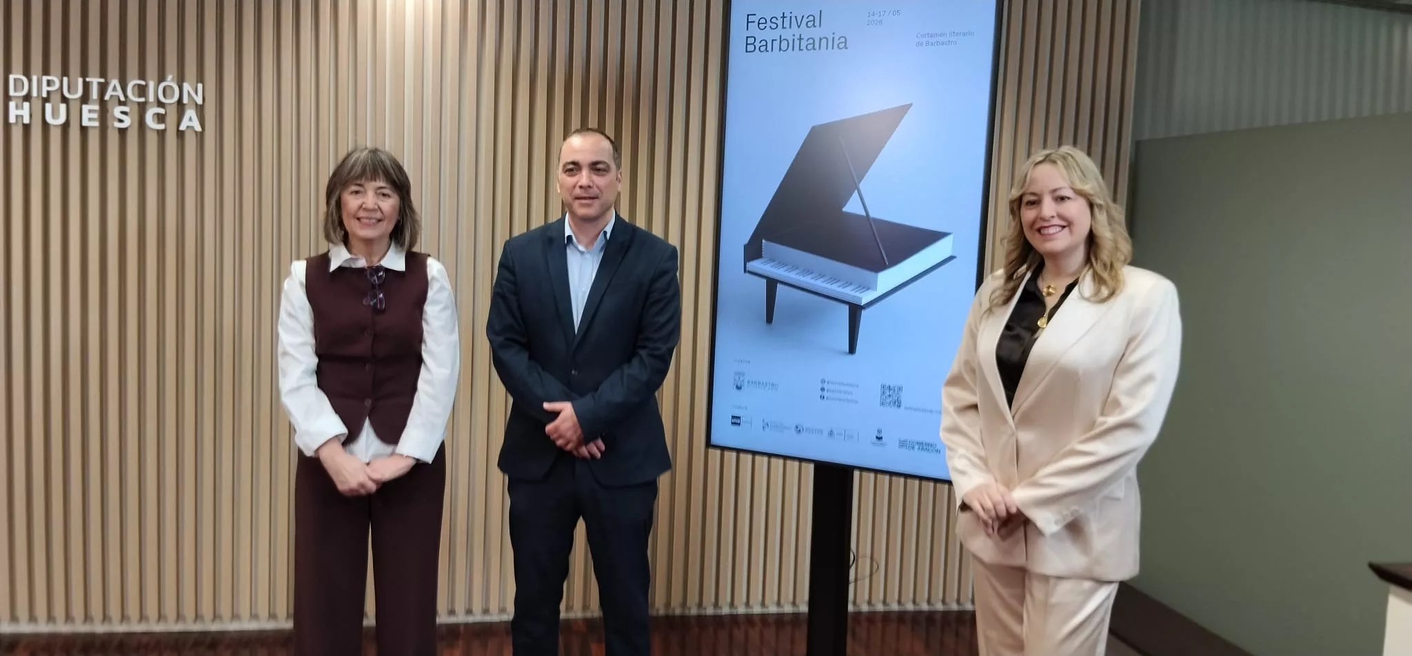 María Ángeles Naval, Carlos Sampériz y Pilar Abad con el cartel de Barbitania, obra de Isidro Ferrer