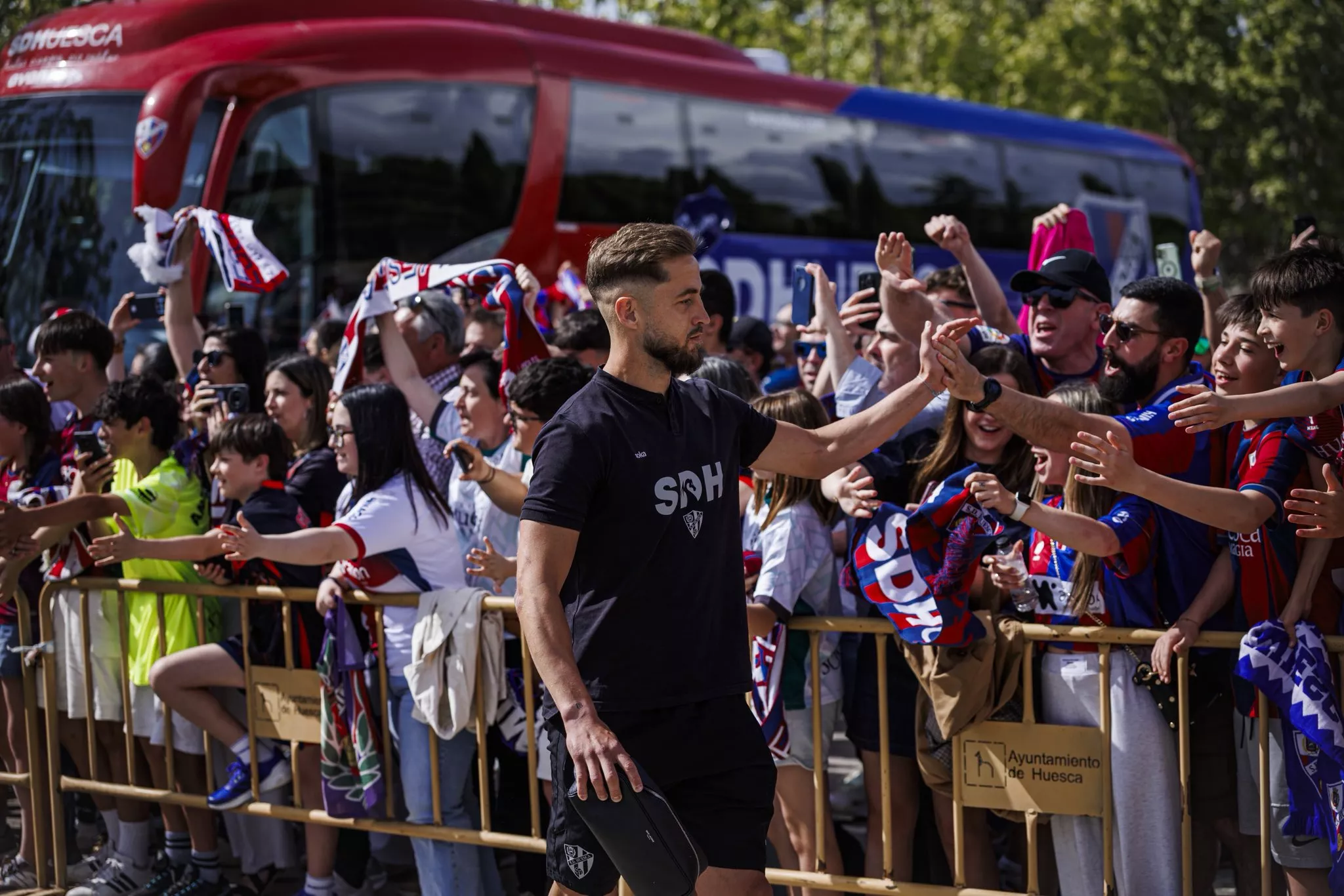 Pulido choca la mano de los seguidores del Huesca. Foto: SDH