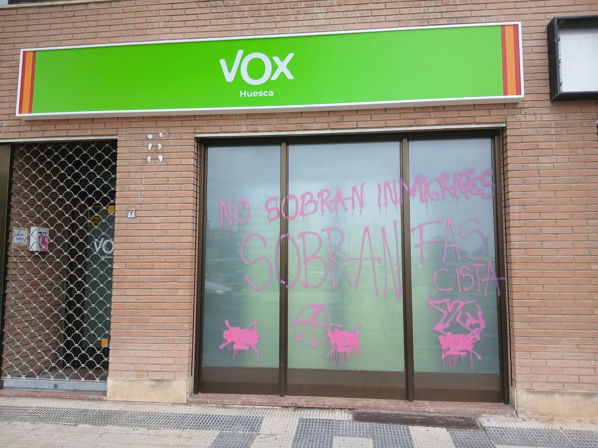 Sede de VOX en Huesca con las pintadas en su cristalera