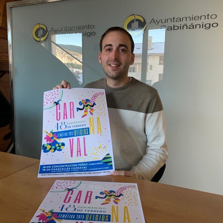 Rubén Lafragüeta sujeta el cartel que anuncia el Carnaval de Sabiñánigo.