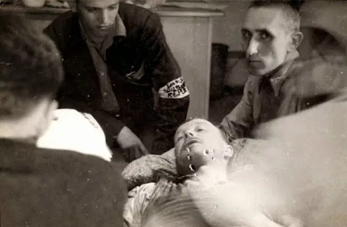 Franz Ziereis en el lecho de muerte. El fotógrafo español Francisco Boix, con un brazalete en el brazo, mira fijamente al que había sido Comandante de Mauthausen