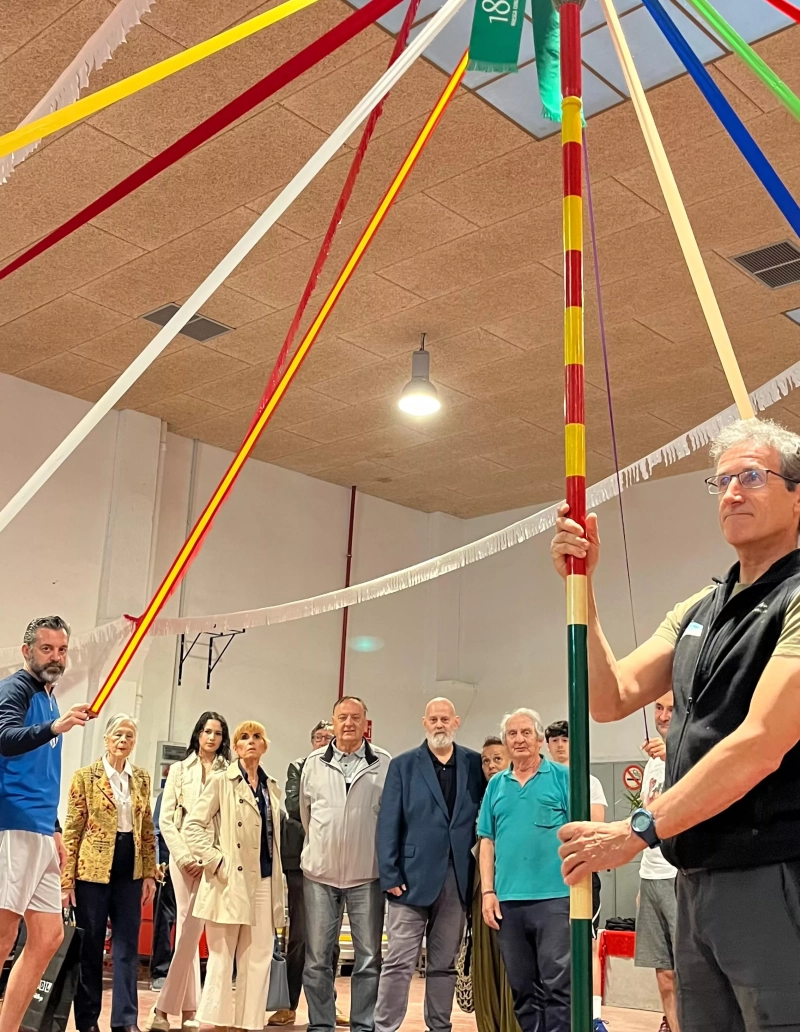 Danzantes y miembros de Cuna de San Lorenzo con el palo de las cintas y el corbatín