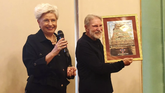 La priora de la Real Cofradía de San Lorenzo Carmen Urzola le hace entrega de un obsequio a Carlos Goñi.