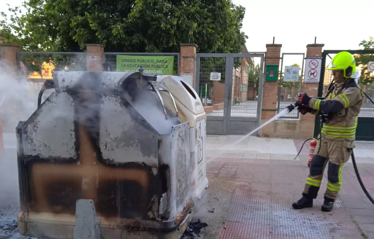 Un bombero apaga un contenedor en la calle Los Olivos