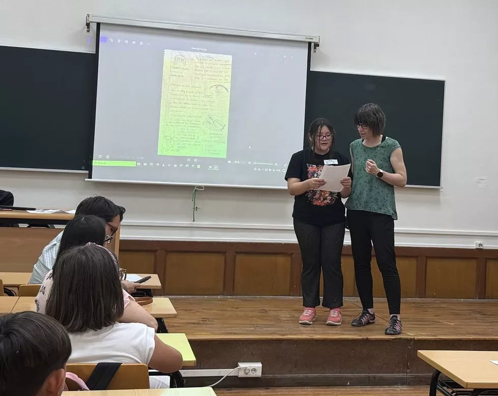 Docente acompañando la lectura del texto de una participante.