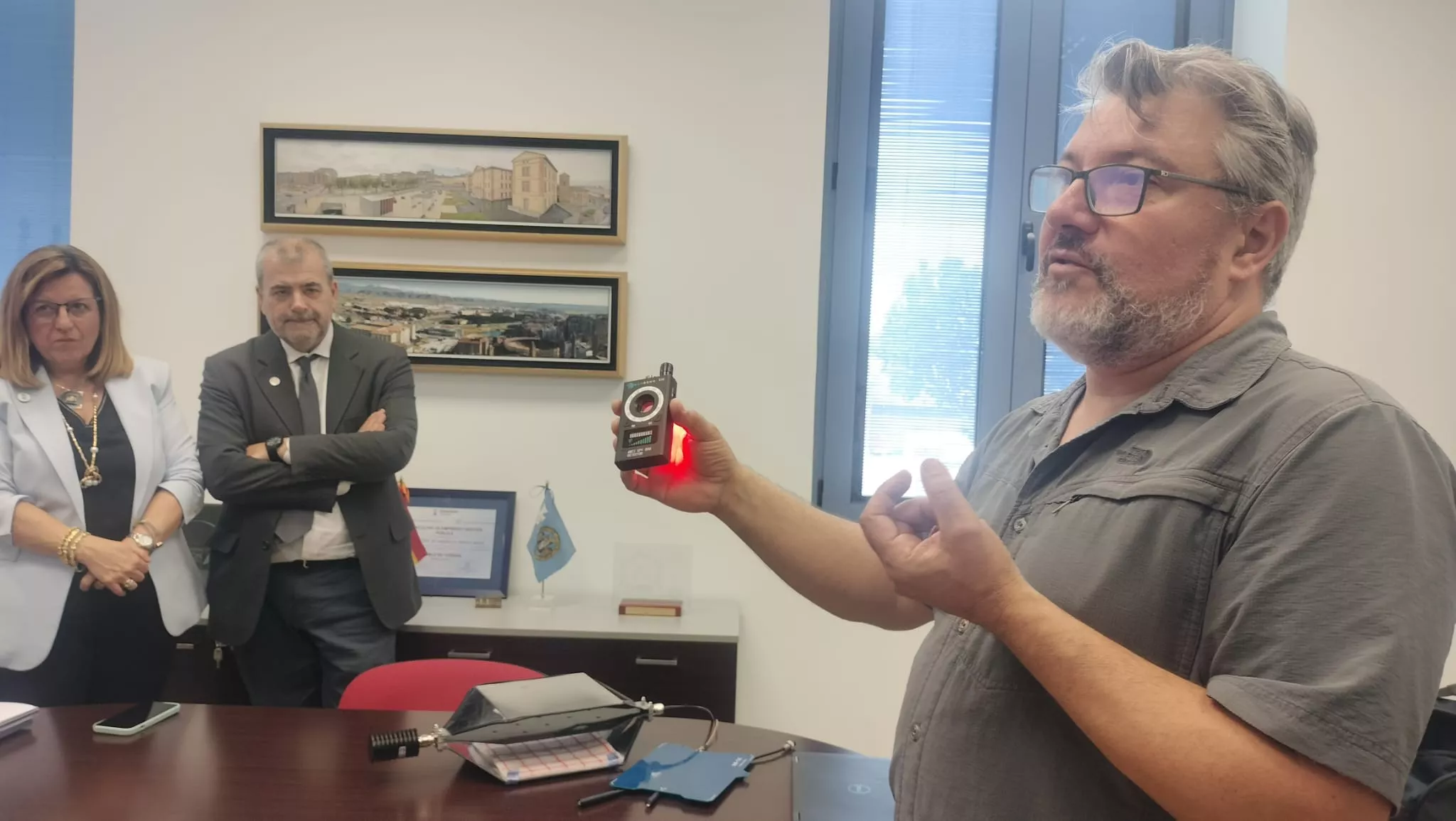 David Asiáin muestra un dispositivo, ante Marta Liesa y Miguel Ángel Barberán.