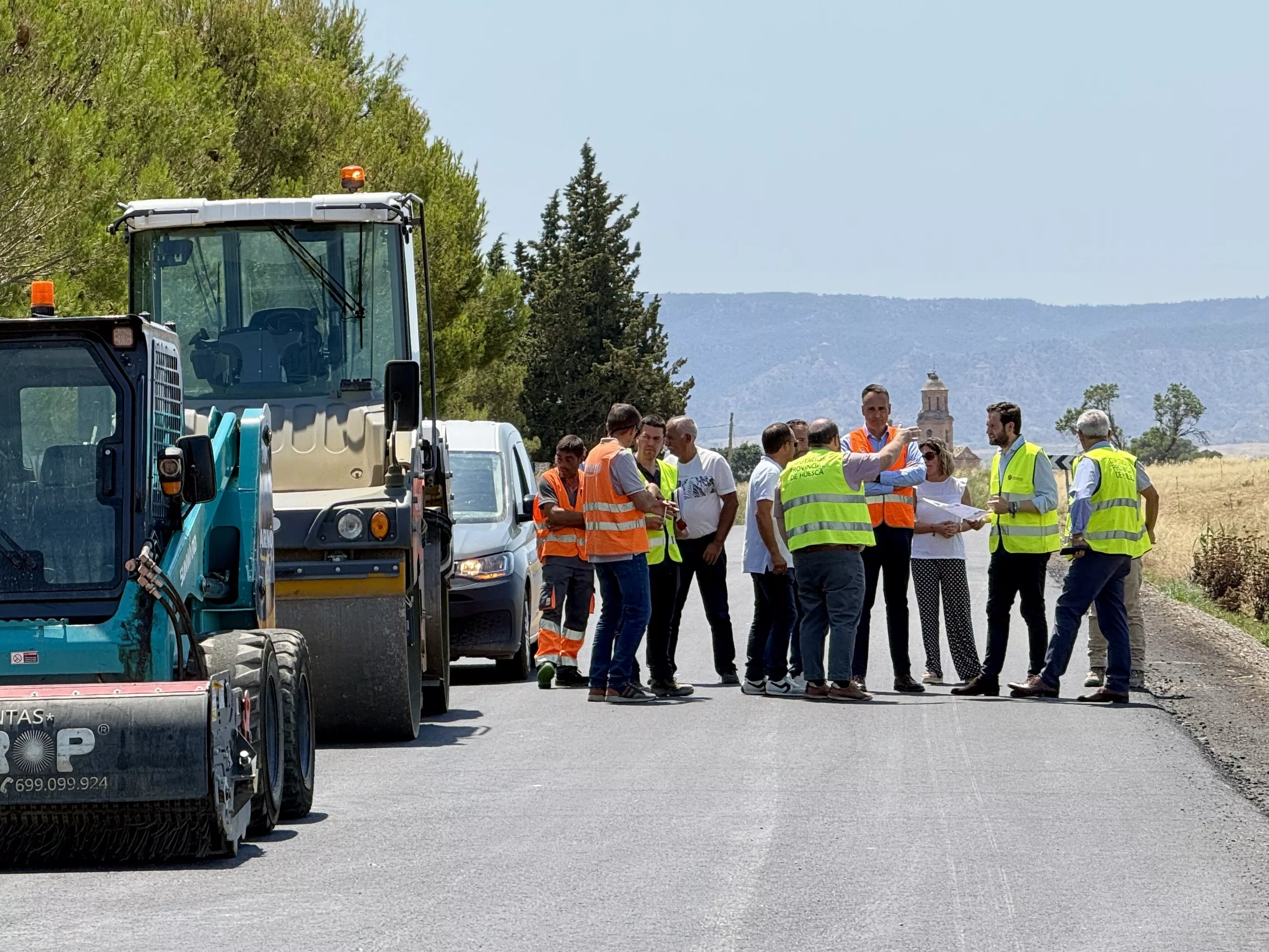 Isaac Claver con Álvaro Bescós y autoridades locales n la carretera entre Sariñena y Albalatillo
