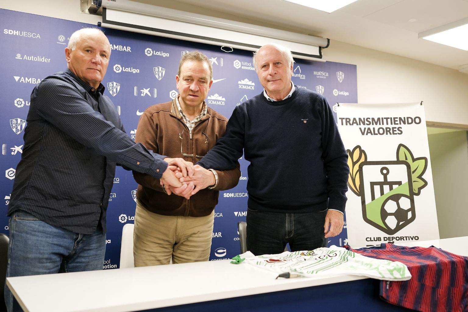 Cuco Lanau, Ignacio Palacio y Pedro Ibaibarriaga tras la firma del convenio entre la SD Huesca y el Peñas Oscenses. Foto: Alejandro Sanagustín