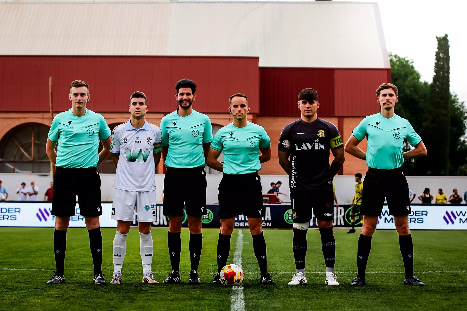 El equipo arbitral con los capitanes de los equipos.
