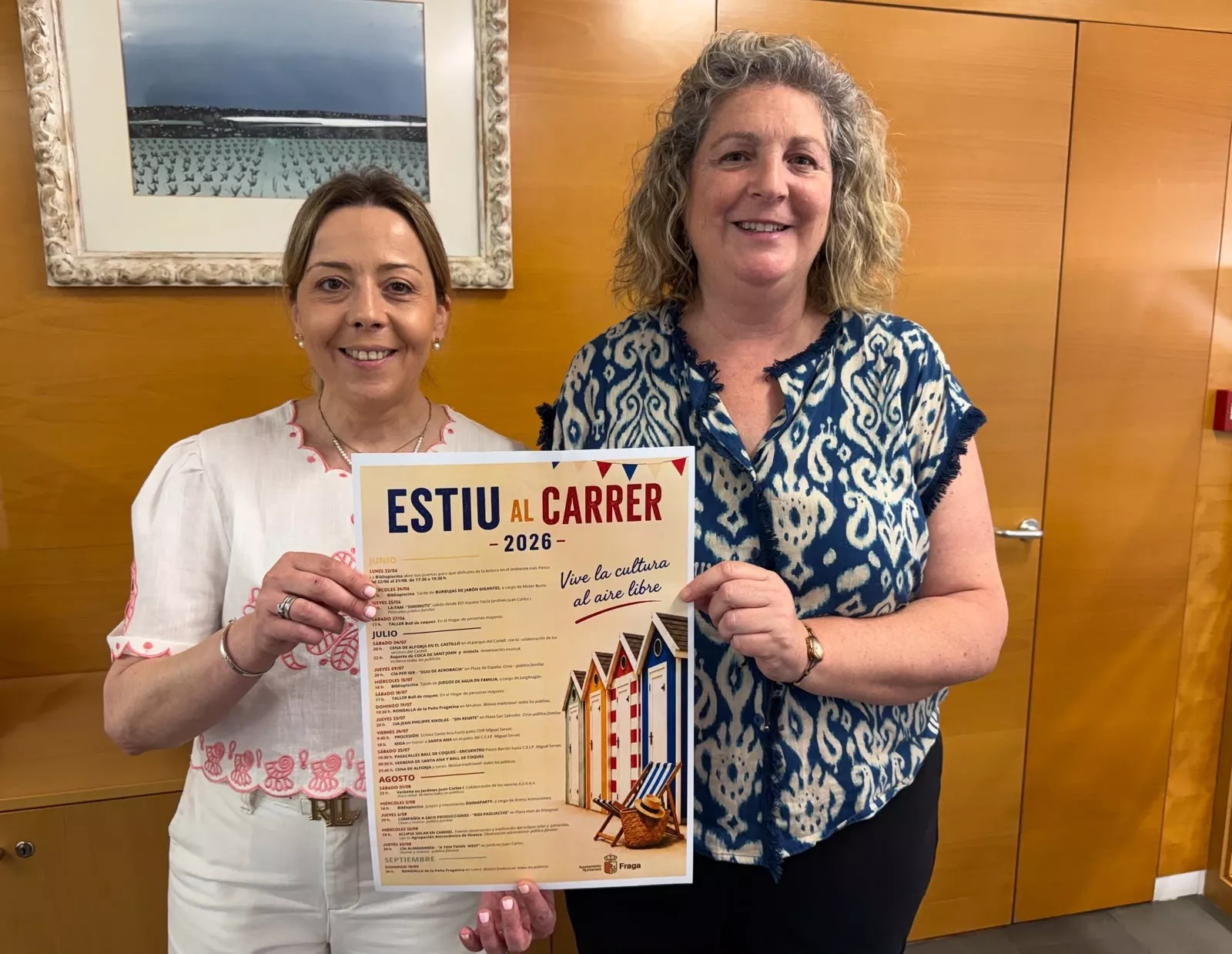 Las responsables del Ayuntamiento de Fraga con el cartel de Estiu al Carrer