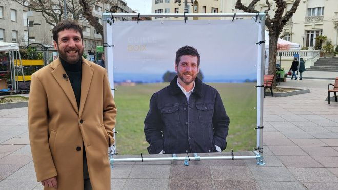 Guillermo Boix, junto a uno de los carteles de la exposición electoral de Podemos. Foto Myriam Martínez