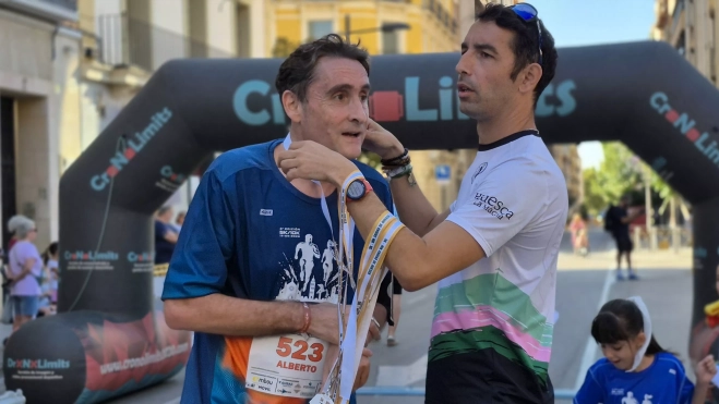 Sergio García entrega una medalla finisher a un corredor. Sergio García entrega una medalla finisher a un corredor.