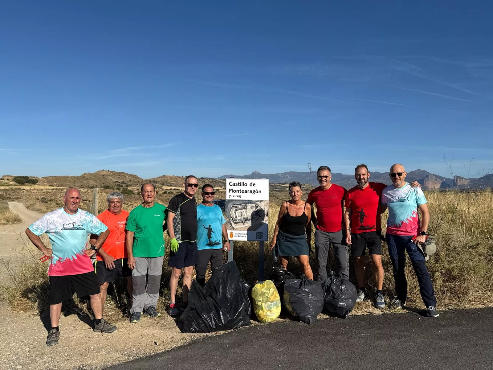 La "brigada" de la limpieza del castillo de Montearagón y su entorno con la basura que han recogido.