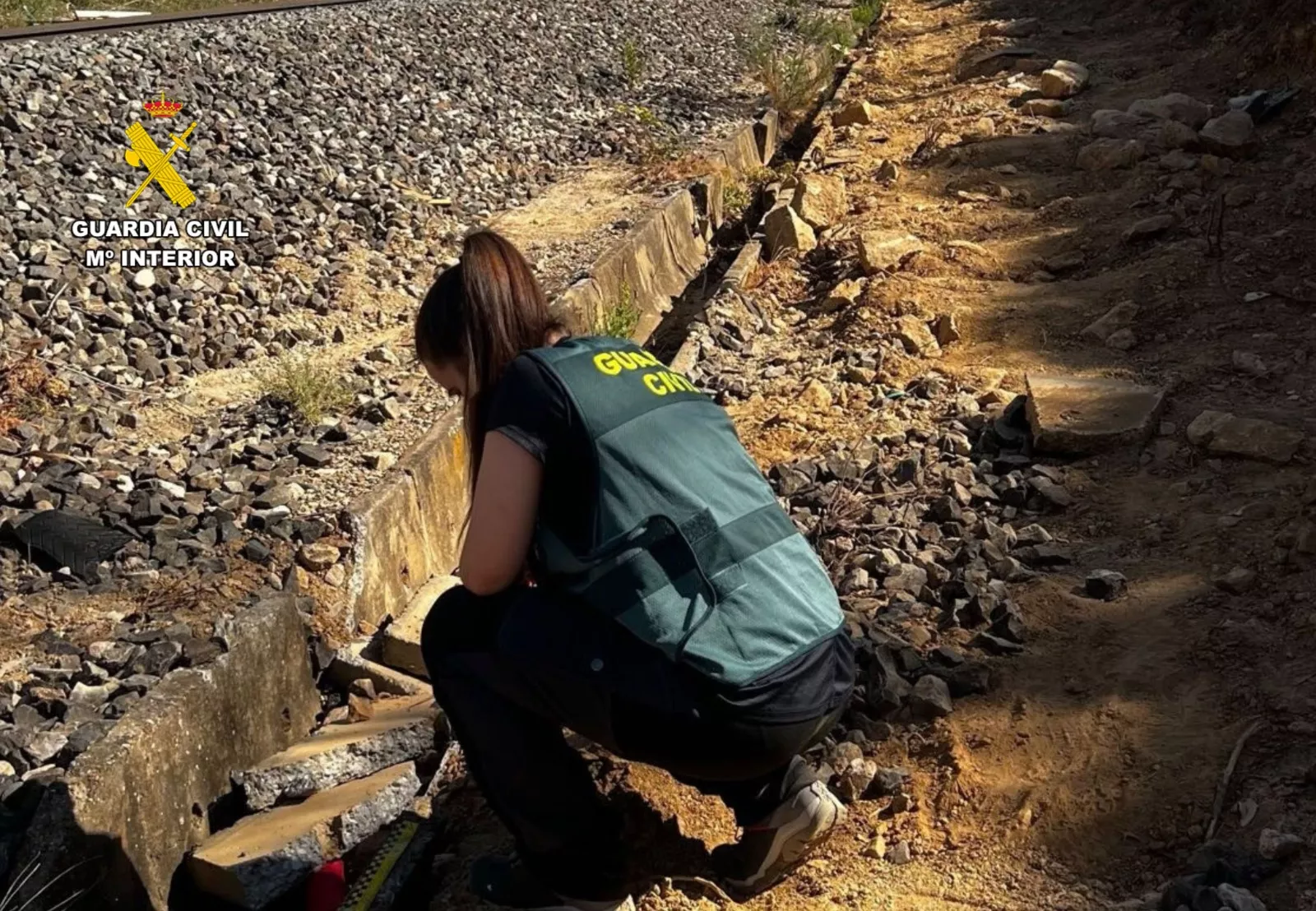 Una agente de la Guardia Civil analiza la vía ferroviaria donde se produjo la sustracción de cobre