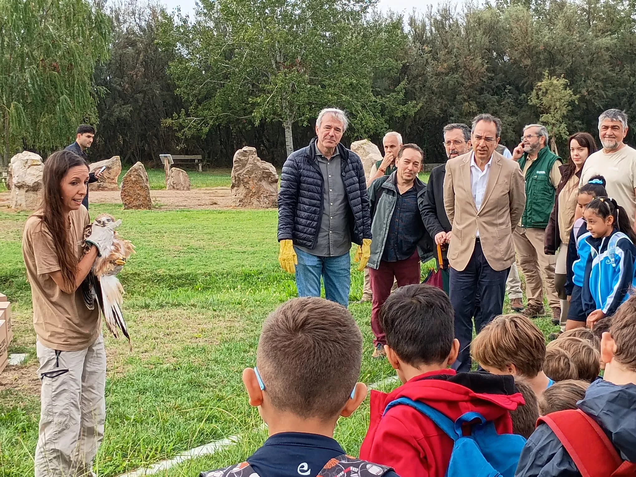 Técnico Ambiental de La Alfranca ofrece explicaciones a autoridades y niños asistentes mientras sotiene un Milano momentos antes de su liberación