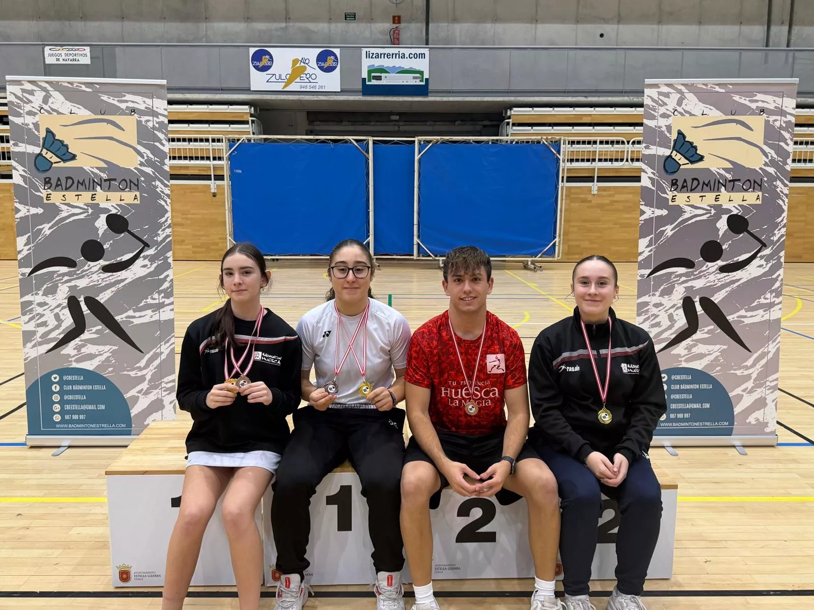 Los cuatro jugadores del Badminton Huesca con sus medallas en Estella.