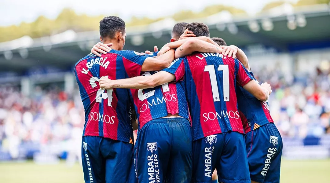 Jugadores del Huesca se abrazan tras un gol en El Alcoraz.