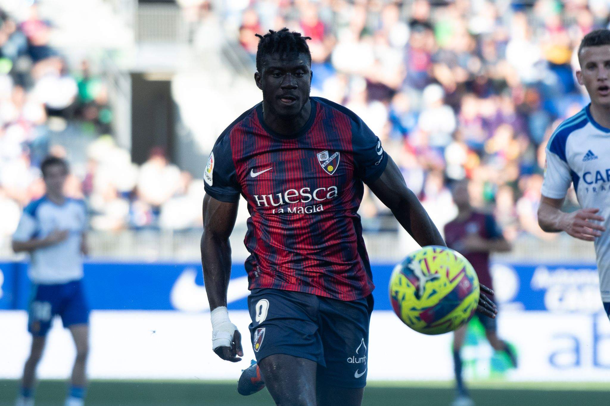Samu Obeng corre a por un balón en el empate del Huesca ante el Zaragoza la temporada pasada. Foto: SD Huesca