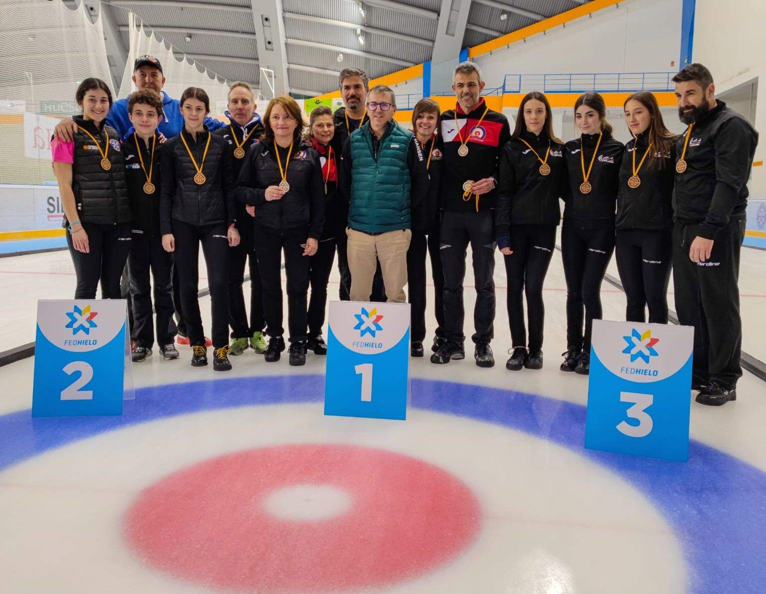 A la izquierda, los jugadores del Jacetania Curling Club Val d'Arán, en el centro, el Jaca Red, y a la derecha, Club Hielo del Pirineo. En el centro, José Ricardo Abad, presidente de la FADI.