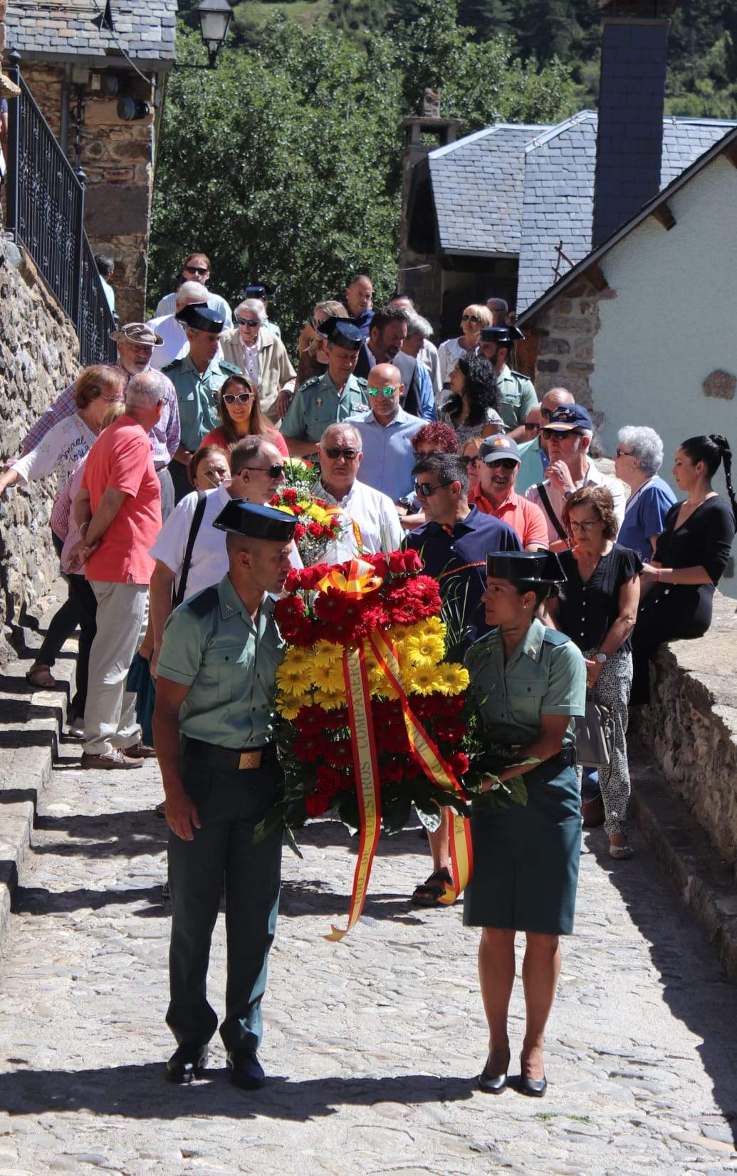 El séquito sigue a los portadores de la corona de flores en Sallent de Gállego.