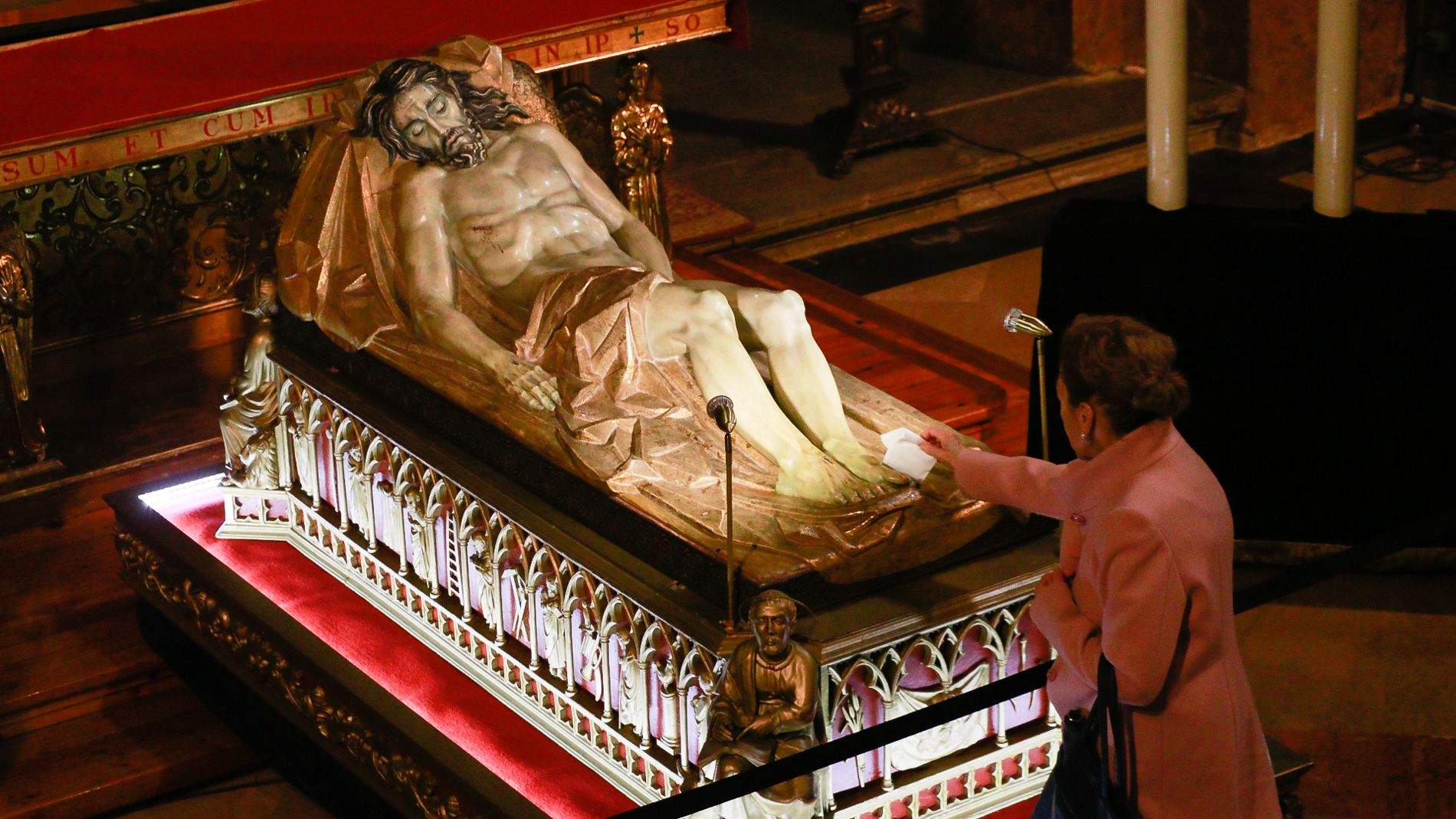 Una mujer rinde culto al Jesús Yacente