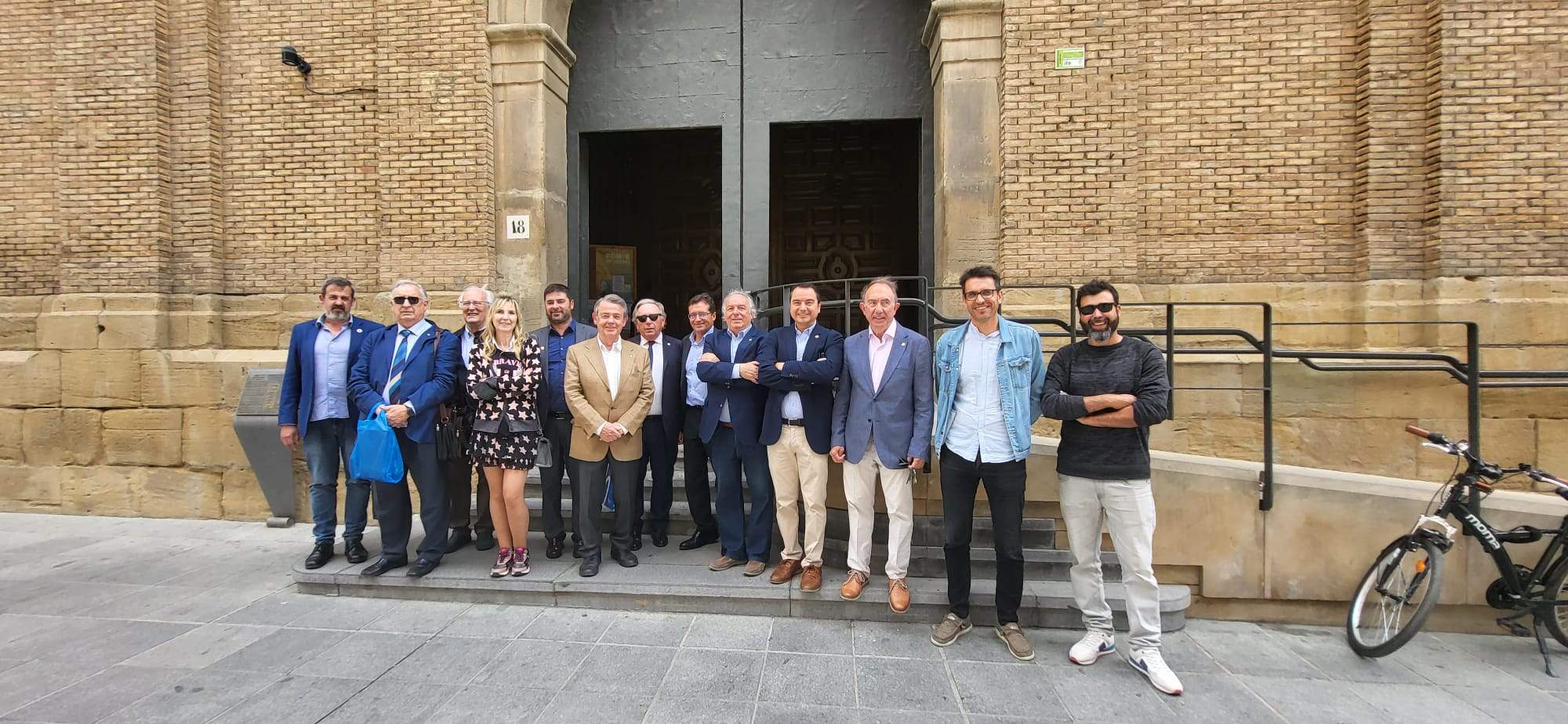 Rotarios de Mérida y Huesca con el presidente de la comarca y el concejal Roberto Cacho ante la puerta de la Iglesia de San Vicente. Foto Javier García Antón