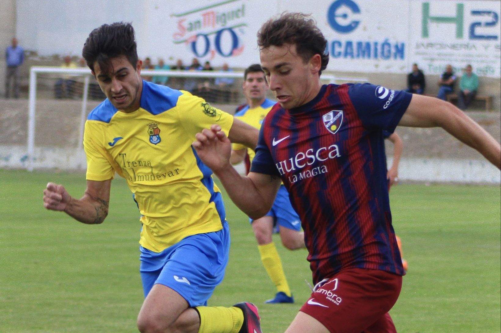 Ballarín, jugador del Almudévar, y Amandi, del Huesca B, pugnan por un balón. Foto: Huesca B