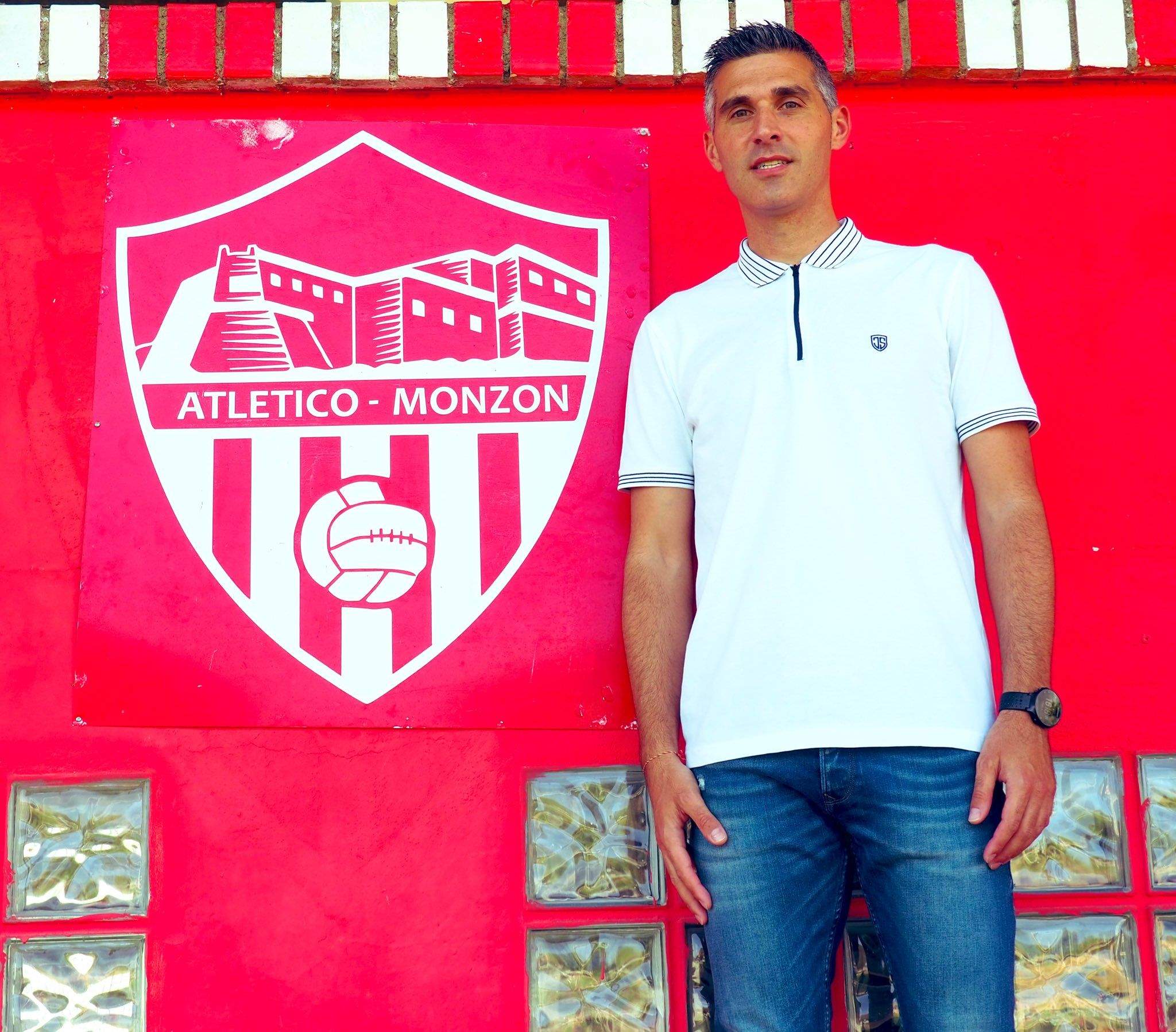 Cristian Abad posa con el escudo del Monzón el día de su renovación como técnico. Foto: Atco. Monzón