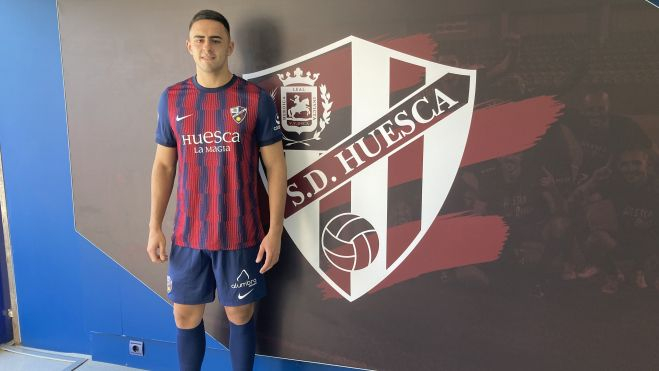 Rubén Pulido posa junto al escudo del Huesca del túnel de vestuarios. Foto: Adrián Mora