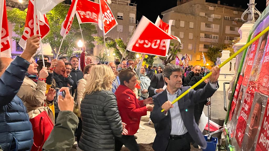 Luis Felipe pega uno de los carteles en el arranque de la campaña.