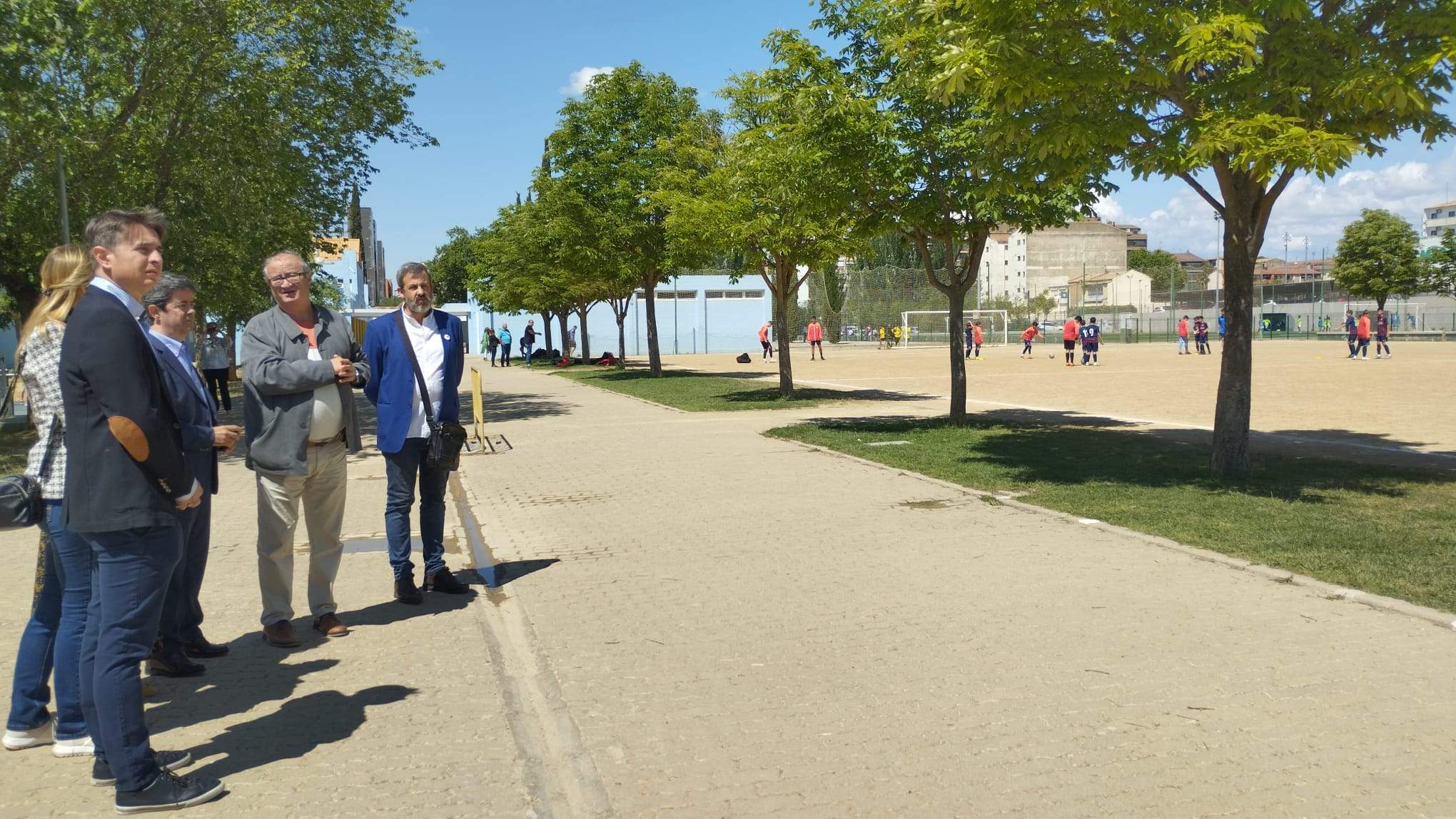 Luis Felipe acompañado por miembros de la candidatura observan el espacio donde se instalará la pista multideporte.