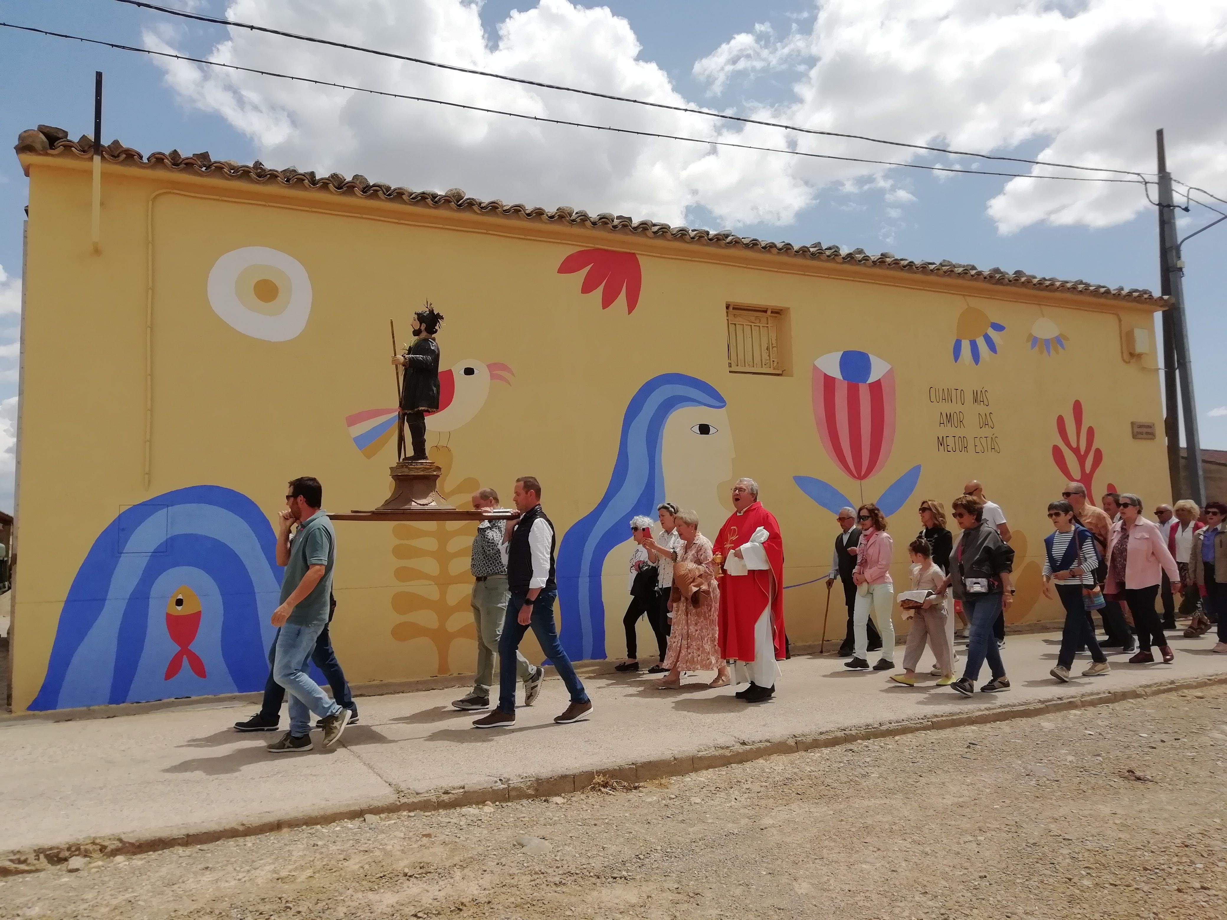 "Cuanto más amor das, mejor estás", Biscarrués pasa junto a la inscripción en la fiesta por Santa Quiteria