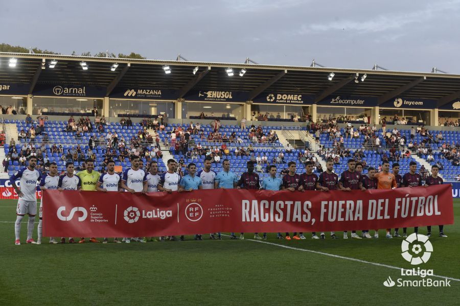 Los jugadores de los dos equipos, con la pancarta contra el racismo