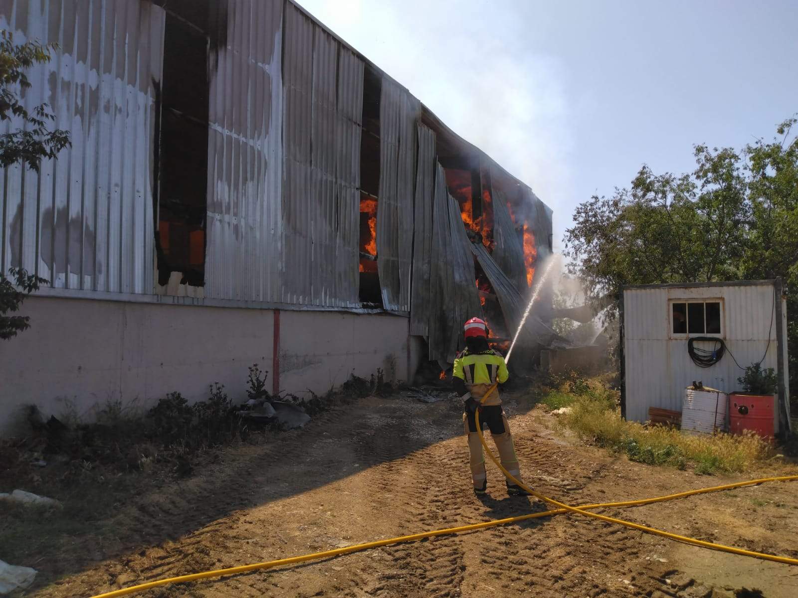 Bomberos trabajando en un incendio que se ha producido en una nave agrícola de Azlor.