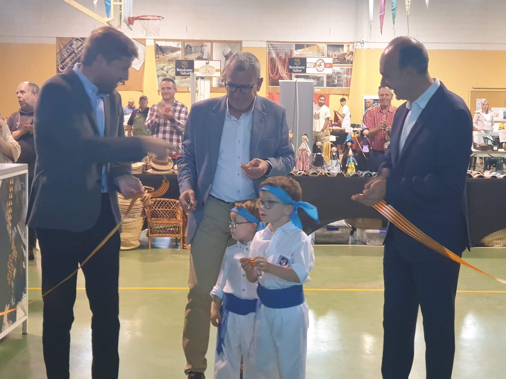 Marcel Iglesias, Francesc Boya y Alfredo Sancho cortan la cinta con dos jóvenes ataviados con atuendo regional en la Fira de Sant Medardo.