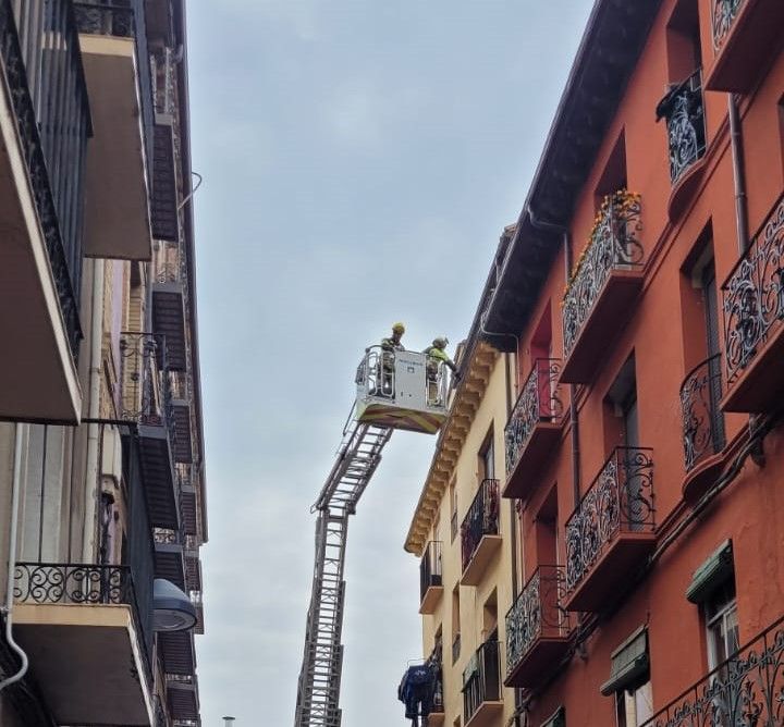 Los bomberos interviniendo para evitar la caída de tejas desde la cubierta del número 12 de la calle San Lorenzo.