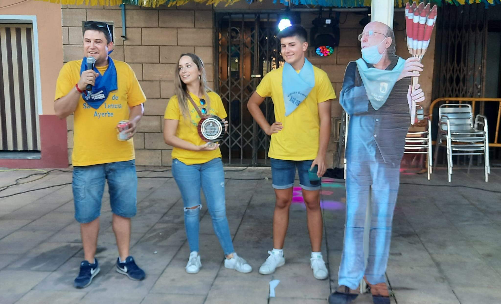 El alcalde, Antonio Biescas, la concejala de Fiestas, Nerea Salcedo, y Diego Esco, miembro de la Comisión de Fiestas le entregan una placa conmemorativa a Lazcorra (a su doble, porque él ha preferido estar en un segundo plano). Foto Ayuntamiento de Ayerbe