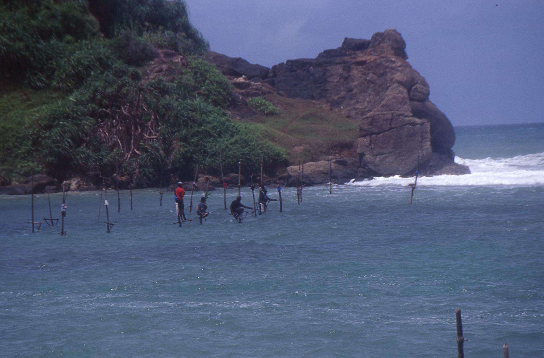 Pescadores sobre palos