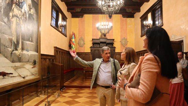Ricardo Oliván, primer teniente de alcalde, explica el cuadro de la Campana de Casado del Alisal a Natalia Chueca